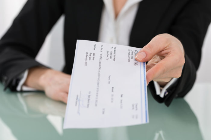 servicesource employer handing employee a paycheck