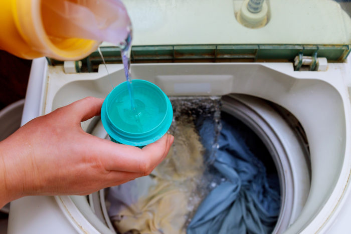 purex liquid laundry detergent being poured into washing machine
