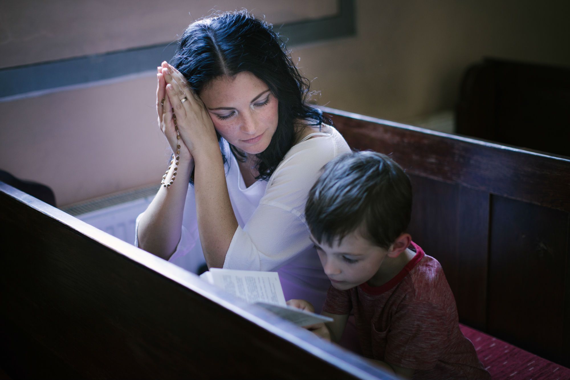 A woman and boy sit in a church.