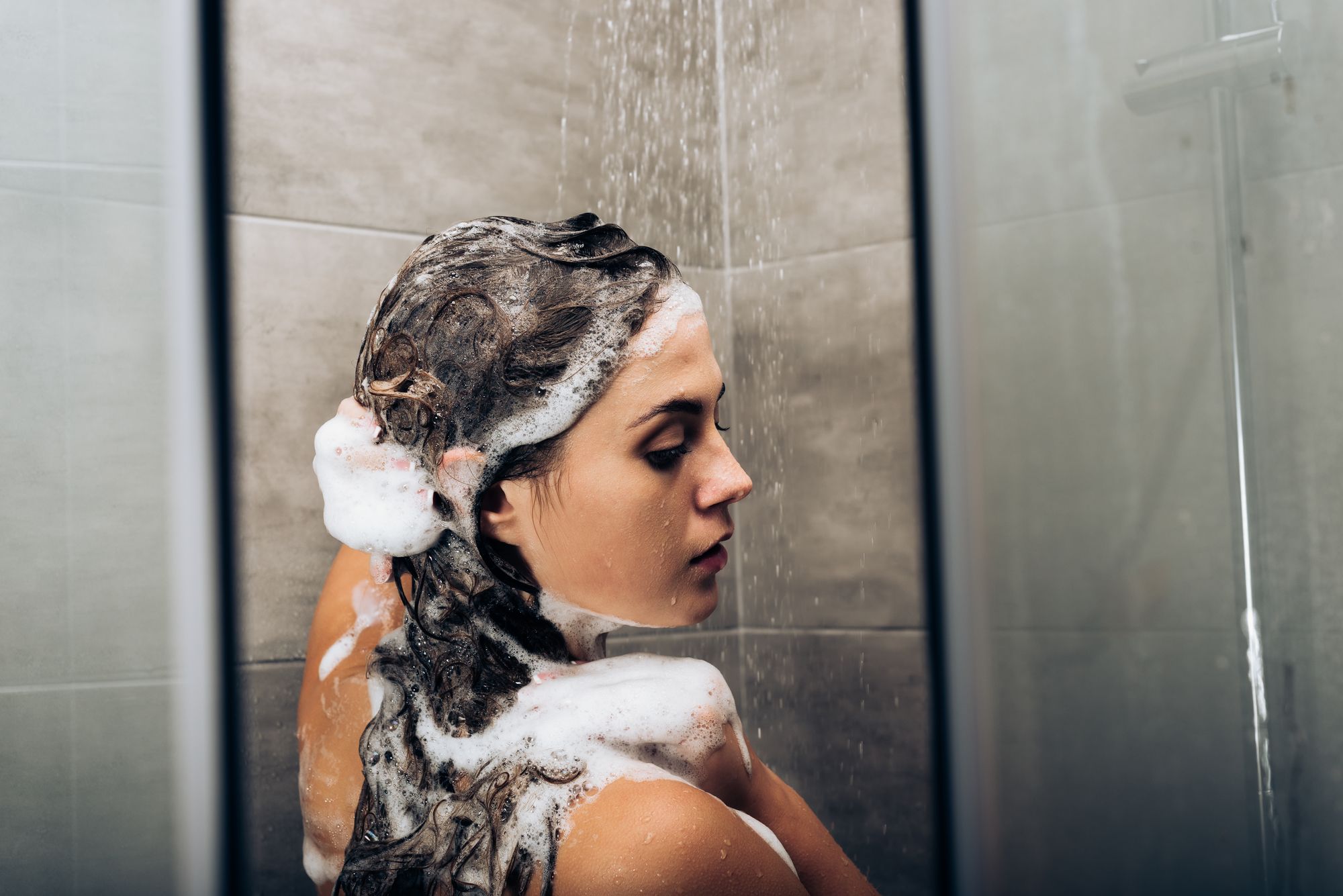 woman using matrix biolage shampoo to wash her hair in the shower