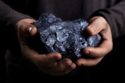 Man who lives with black lung holds a chunk of coal