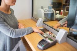 Bank teller gives money to customer.