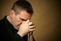 Catholic priest praying