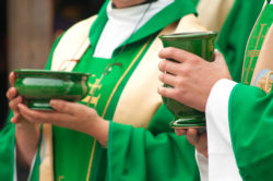 Close up of priests holding wine and bread during Mass.