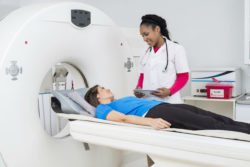 A doctor looks at a patient about to undergo MRI