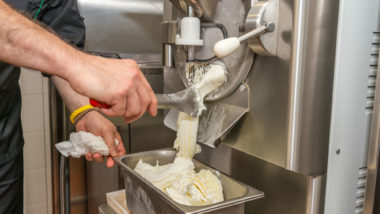 Ice cream pours out of a machine.