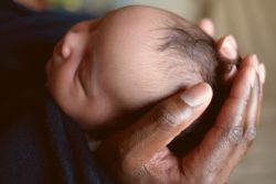 Newborn baby held by father