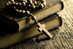 A rosary lies on two old books.