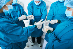 Surgical team putting on gloves