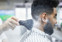Barber puts talcum powder on customer's neck