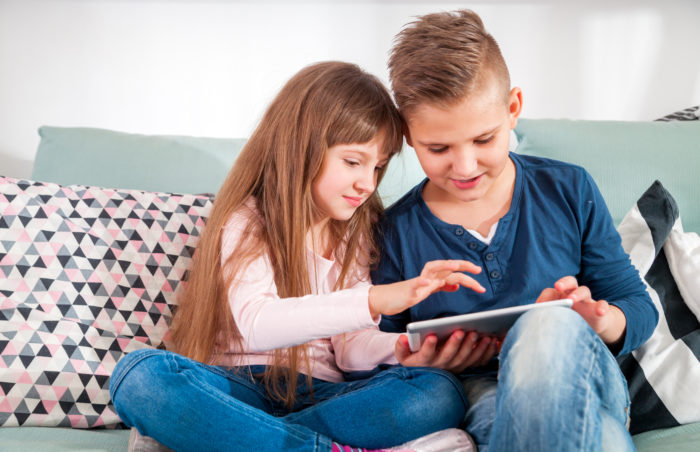 boy and girl playing Disney games on tablet