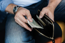 Hand removing cash from a wallet