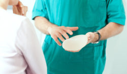 Doctor showing breasts implants to female patient