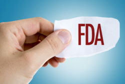 Hand holding paper with FDA sign