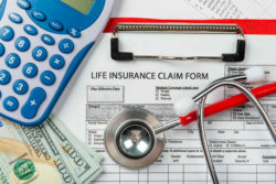 Life insurance claim form with calculator, money, and medical items