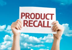 Hands holding product recall sign