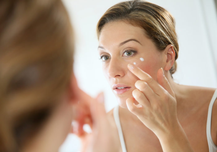 woman applying Nivea skin firming lotion