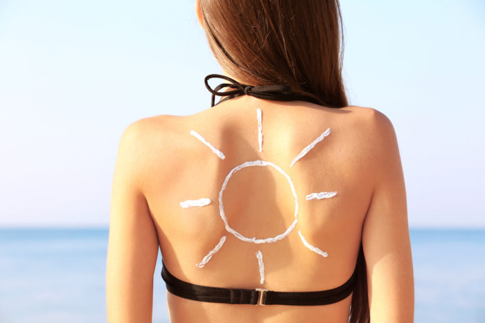 sunscreen sunblock on woman's back