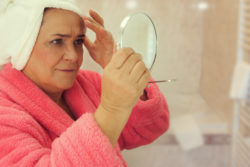 Woman looking at herself in the mirror in bathroom