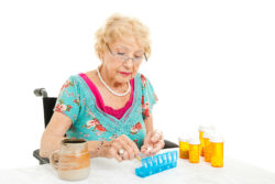 A woman puts pills into a pill counter.