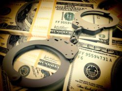 Fraud concept with handcuffs on money