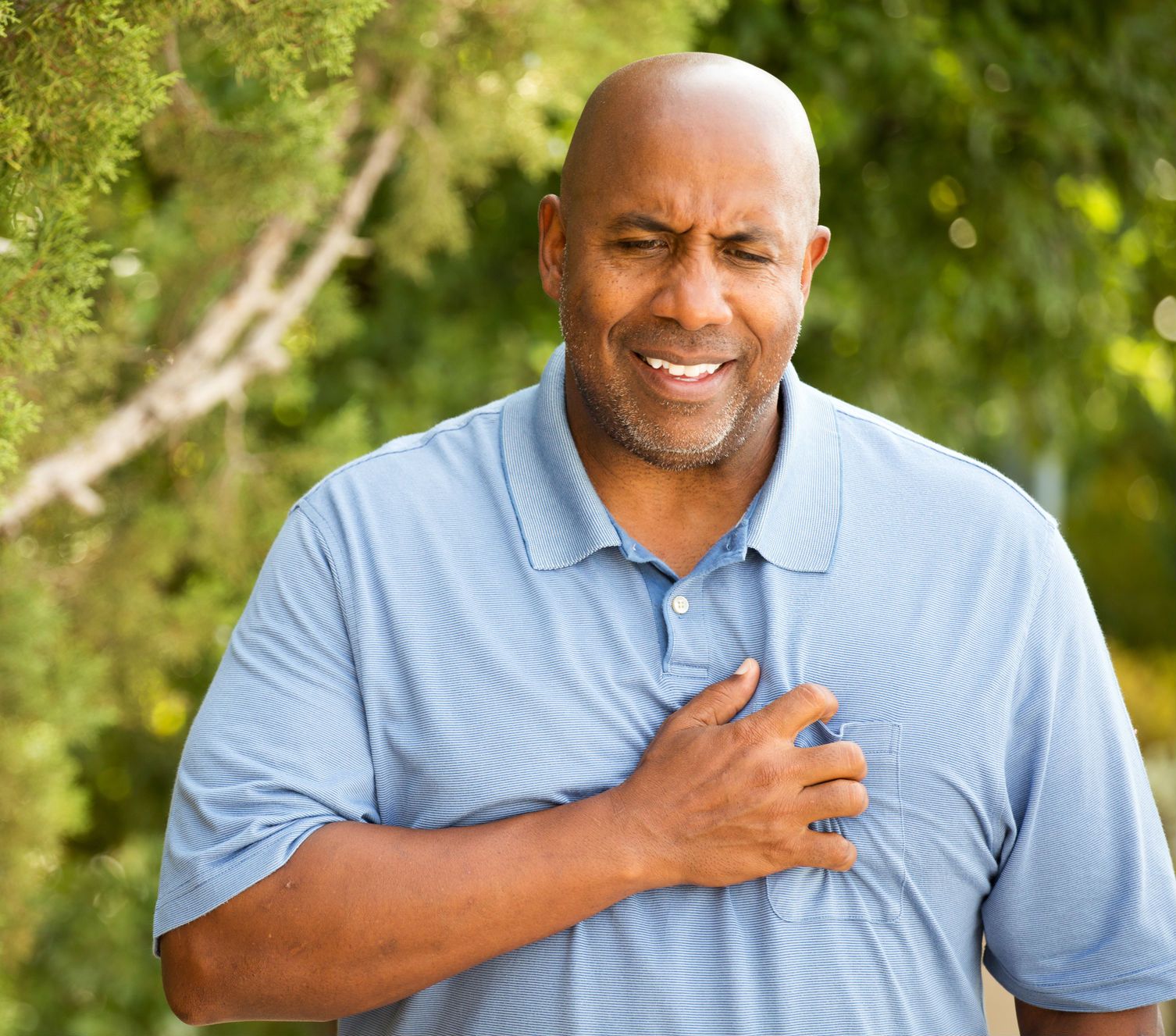A man holds his chest in pain.