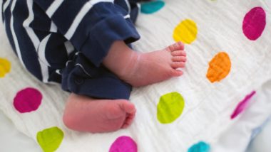 Newborn feet on polka dot blanket