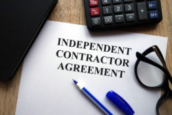 Independent contractor agreement with pen, glasses, calculator