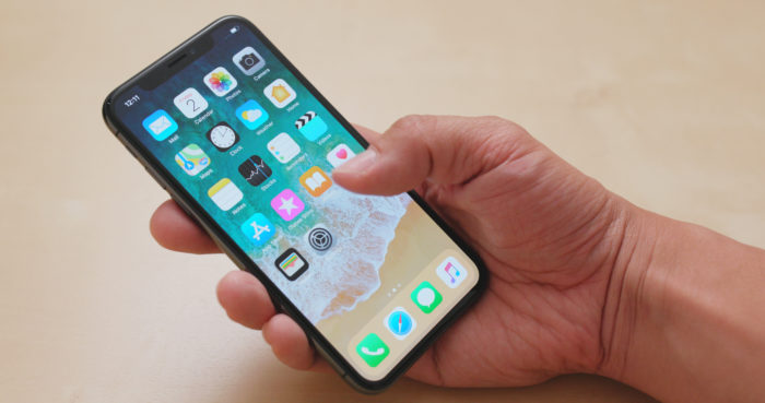 woman holding iPhone x with apple apps open