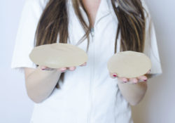 A nurse holds two textured breast implants.
