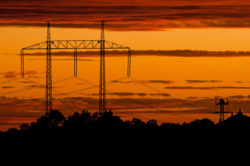 Sunset behind a power line tower