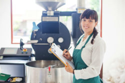 A woman works at a coffee roaster.