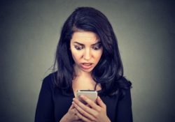 Worried woman looking at cellphone
