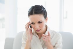 Frowning stylish brunette businesswoman making a phone call