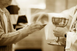 A priest gives communion at mass.