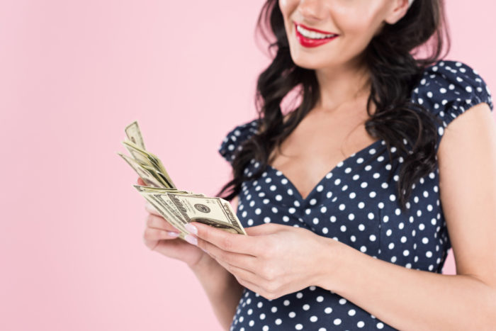 woman holding money from a class action settlement