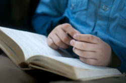 Child's hands on open book