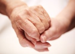 elderly hand being held