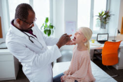 A doctor treats a young patient.