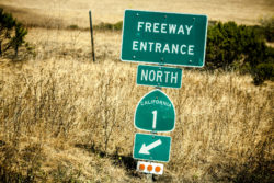 A sign marks the entrance to a freeway.