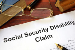 Social security disability claim on wooden table with pen and glasses
