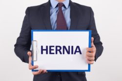 Man holds paper that says hernia