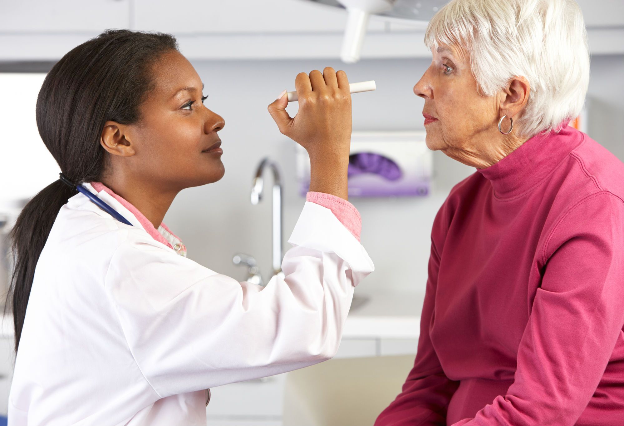 An eye doctor examines a woman's eyes.