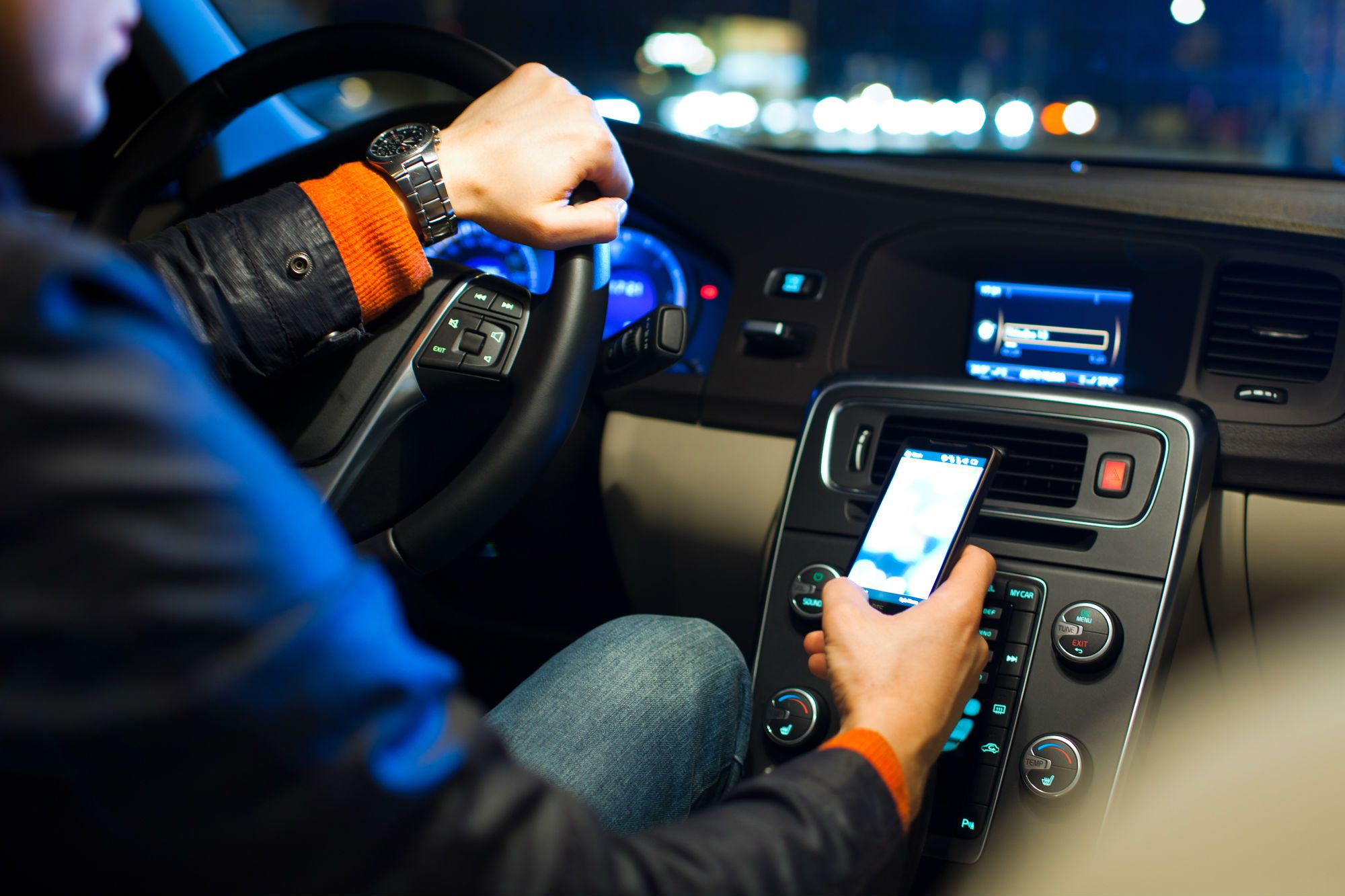 A rideshare driver checks his cellphone. - Uber lawsuit