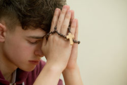 Teen Boy praying rosary