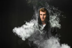 Young man in a cloud of vape