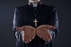 Catholic priest with open hands