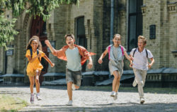 Children run outside a school.