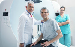 A man waits for MRI scan with doctor and nurse