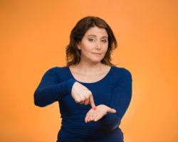 A woman points to her palm indicating she wants money back.